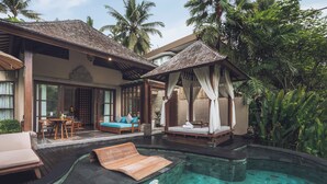 A pool area with a lounge chair, a wooden deck, and a canopy bed.