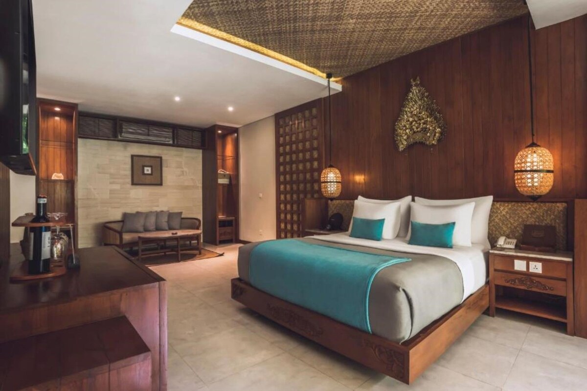 Una habitación de hotel moderna con una cama grande, un escritorio, un sofá y un panel decorativo en la pared.