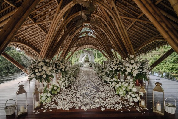 An arched wooden structure with a floral aisle.