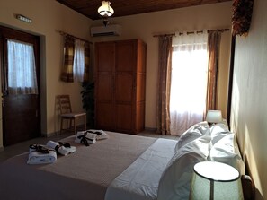 A bedroom with a bed, a chair, a wardrobe, and a lamp. - First floor apartment with beautiful mountain and sea view near the sea (Στούπα)