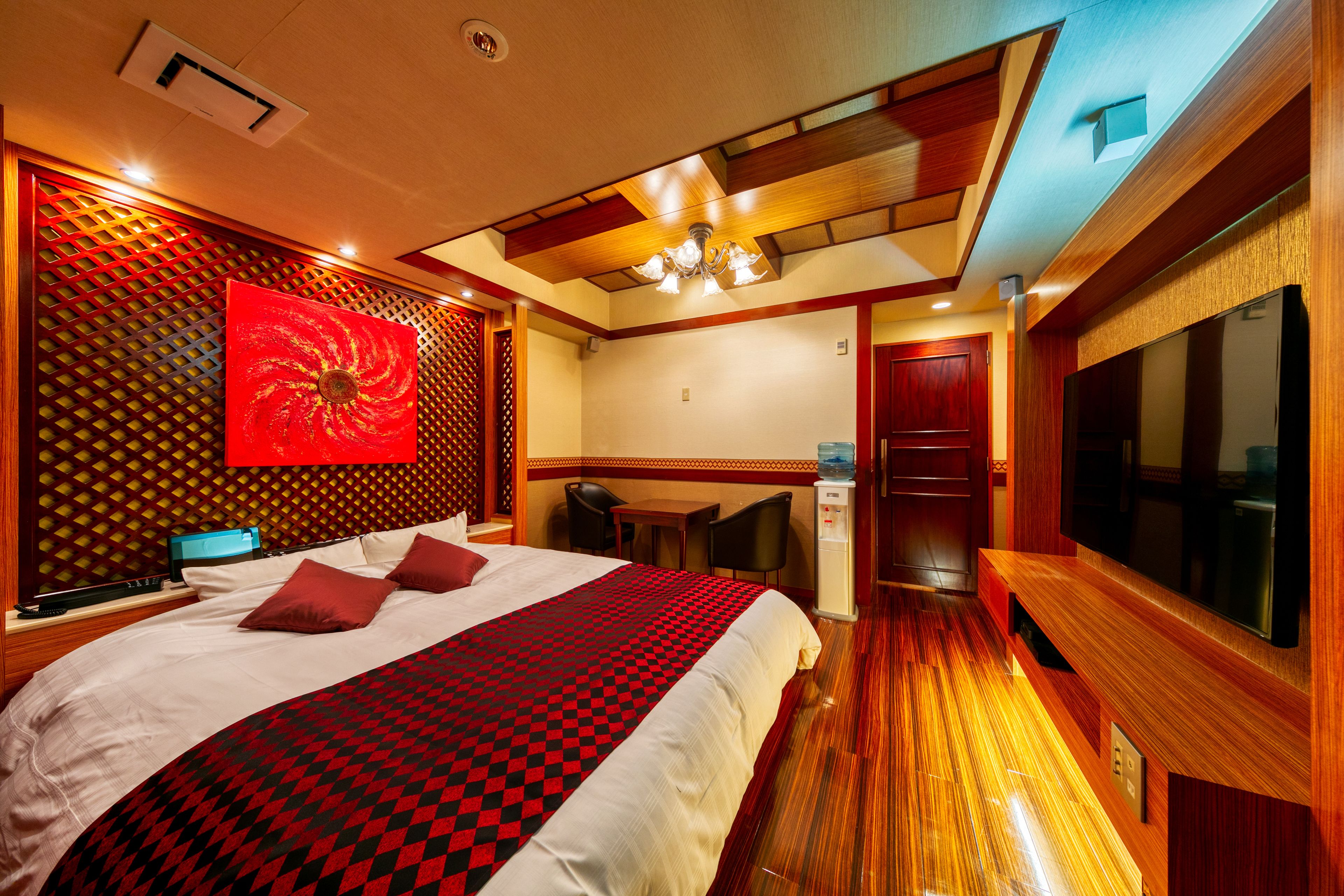A hotel room with a large bed, a desk, and a TV.