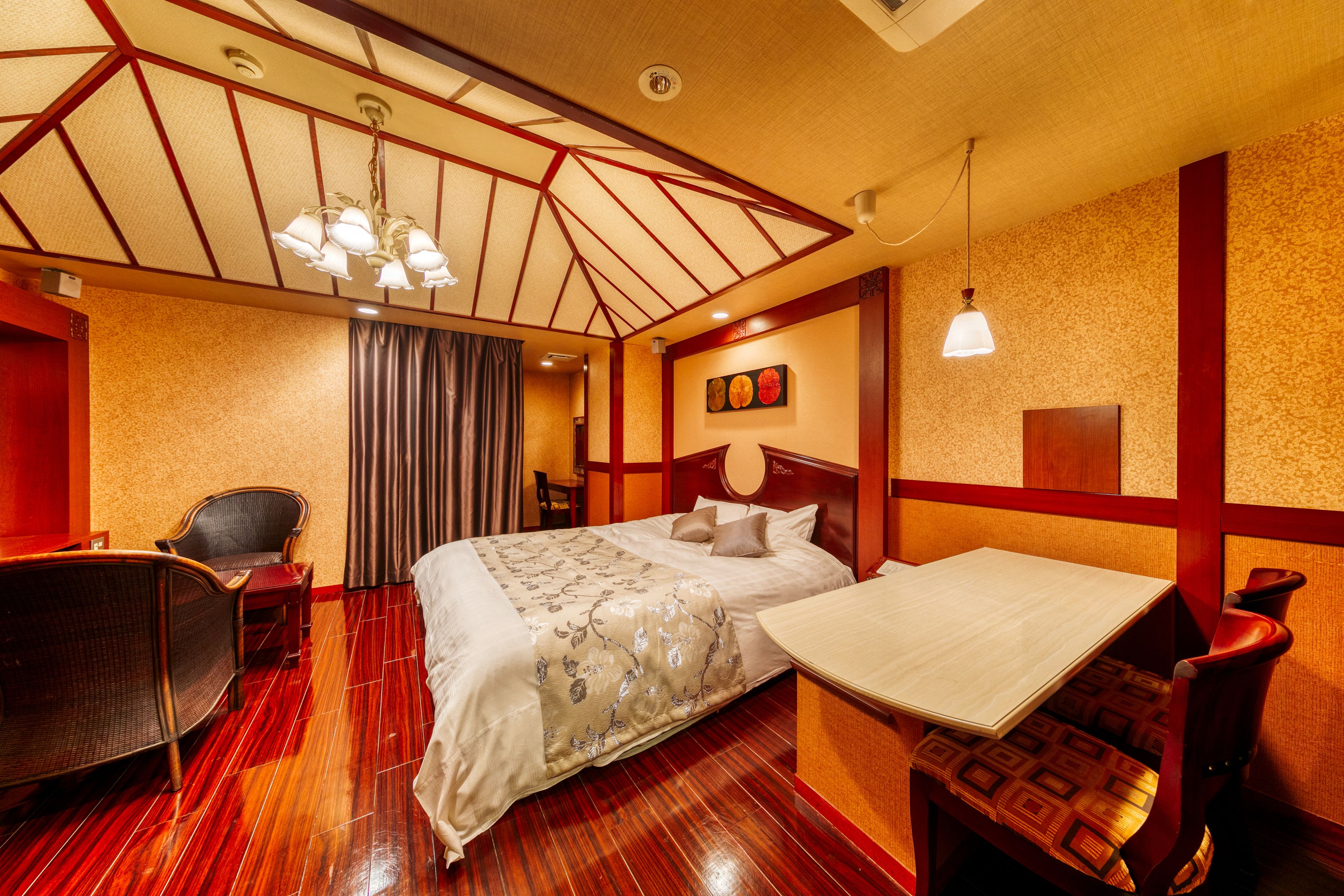 Een hotelkamer met een bed, een bureau, een stoel en een eettafel.