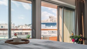 A hotel room with a large bed, a view of a historic building, and a balcony with a railing. - COCO-MAT Athens BC (Athens)