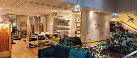 A spacious interior with a fitness area, a sofa, and a variety of home decor items.