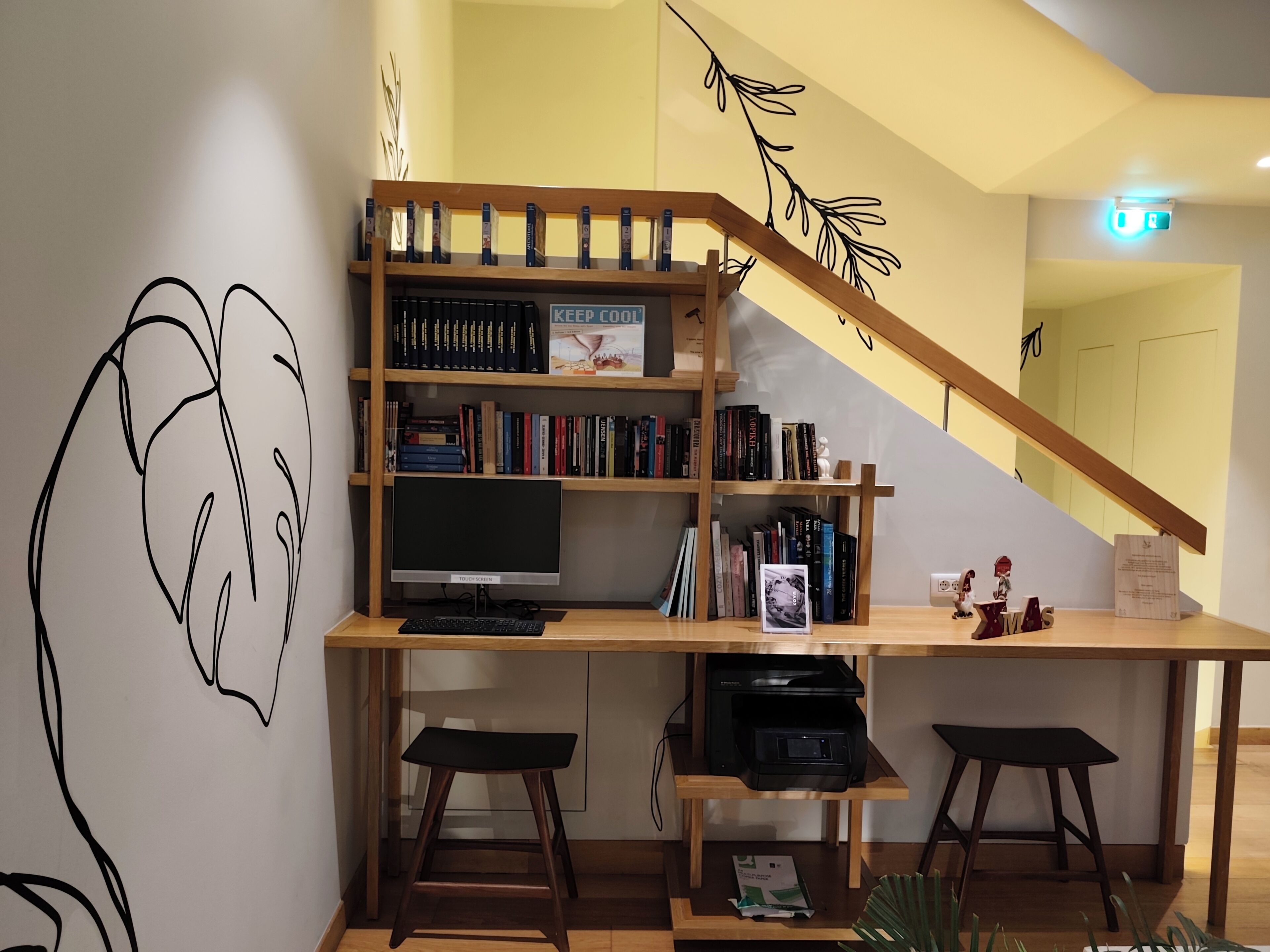 Eine moderne Bibliothek mit Bücherregalen, einem großen Flachbildfernseher und zwei Barhocker.