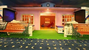 A children's playroom with a slide, benches, and a green carpet with star patterns. - Life Leisure Resort (Guanxi)