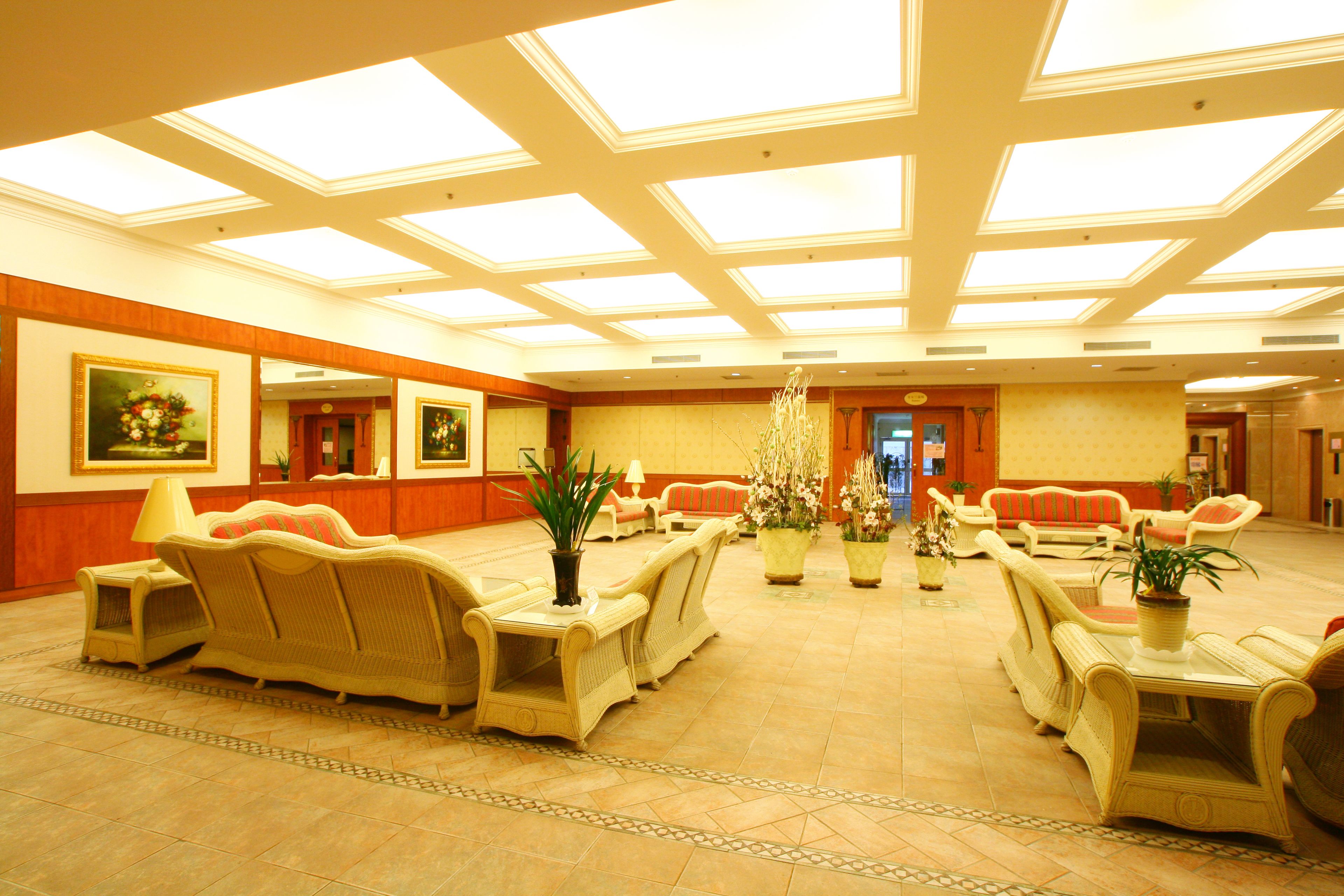 A spacious lobby with high ceilings, large windows, and multiple seating areas with sofas and tables.