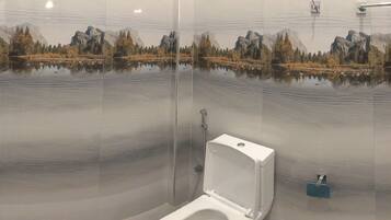 A bathroom with a large mirror reflecting a mountainous landscape.