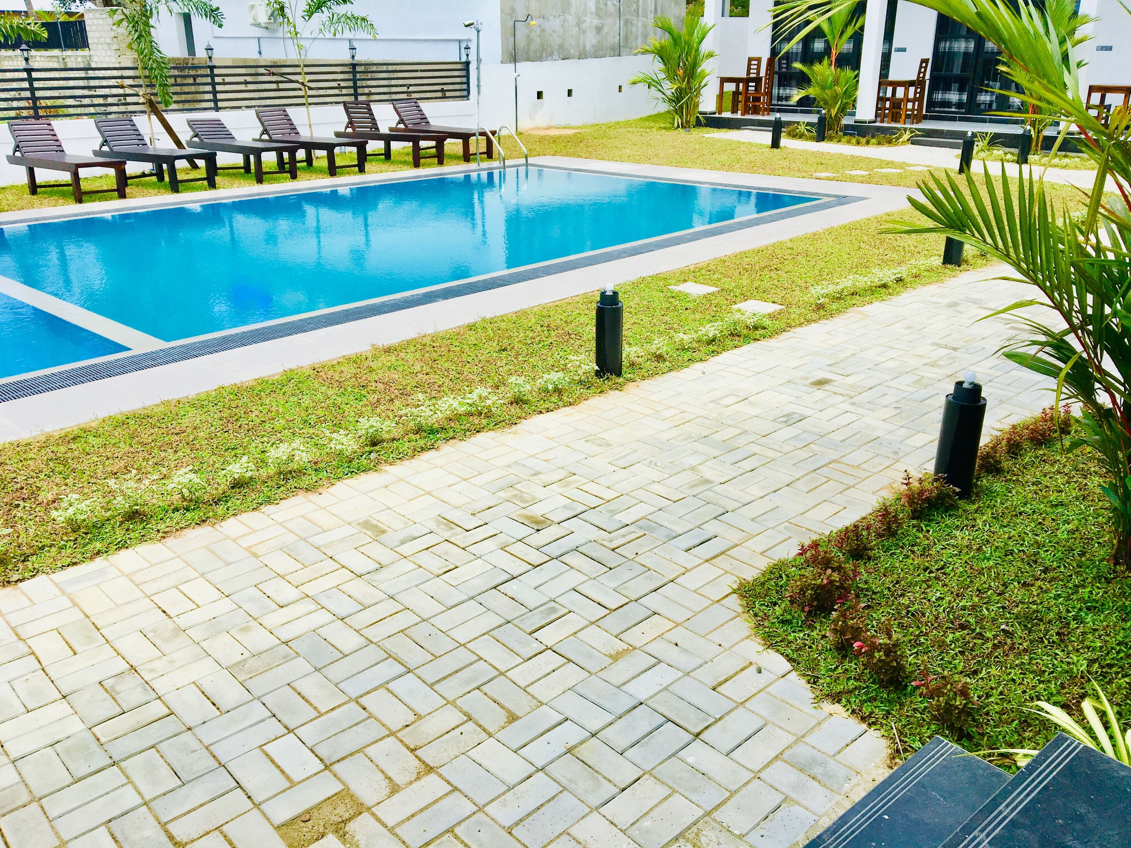 Een buitenzwembad, ligstoelen bij het zwembad