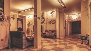 A spacious living area with a checkered floor, a sofa, a coffee table, and a lamp. - OPERA Hostel (Erfurt)