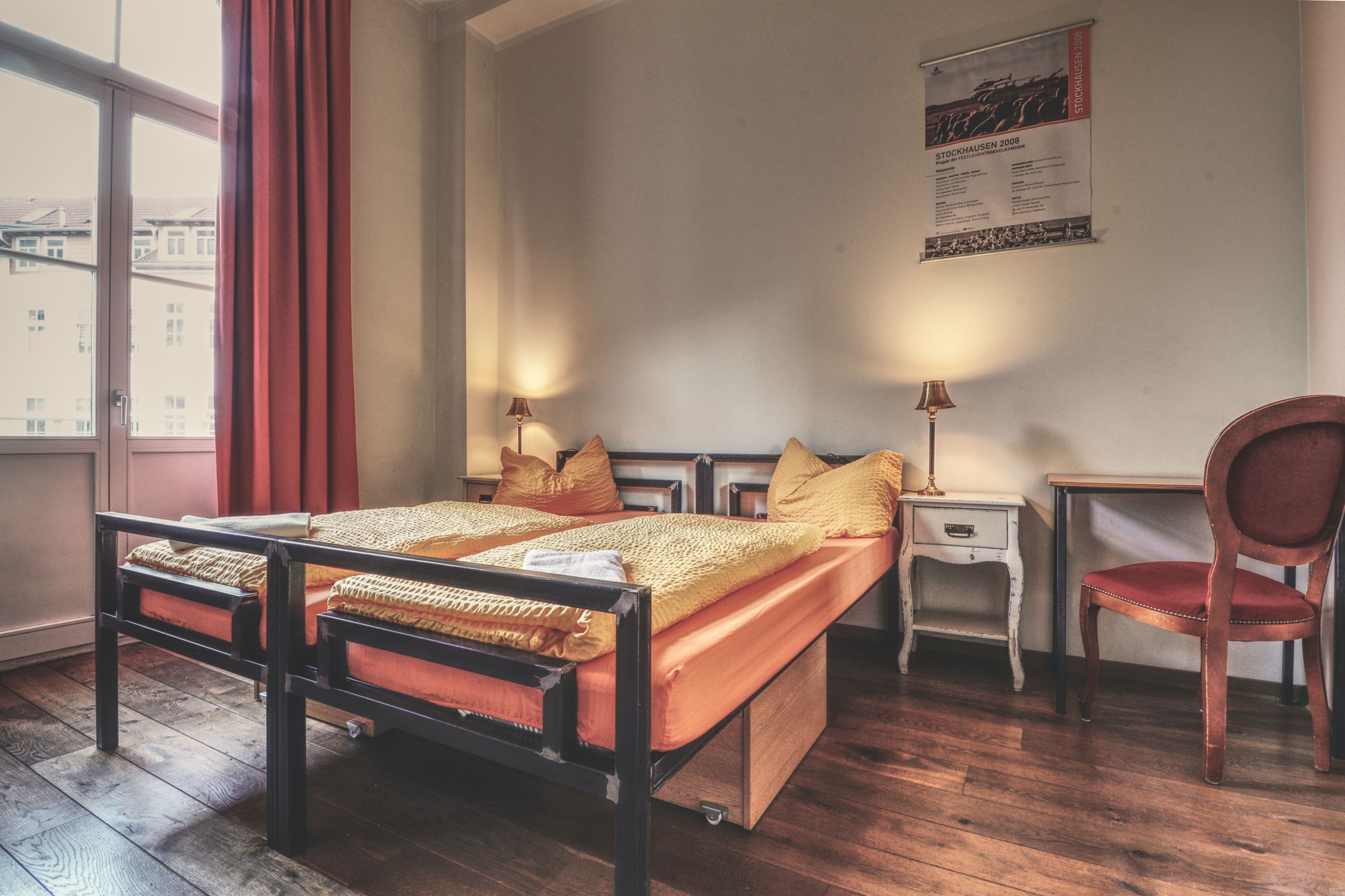 Una habitación con cama, escritorio, silla y ventana.