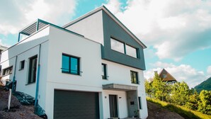 A modern two-story house with a garage, large windows, and a sloped roof. - bikehikesleep (Sasbachwalden)