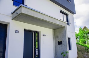 A modern building with a flat facade, a door labeled "12", and a small window to the right. - bikehikesleep (Sasbachwalden)