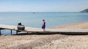 A wooden pier extending into calm waters with a person standing at the end. - Awesome home in Haderslev with WiFi (Haderslev)