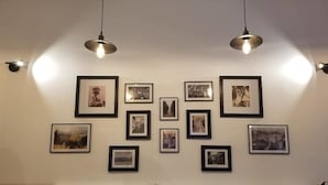 A wall with multiple framed photographs arranged in a grid pattern. - Hotel RELAX Pazari i Vjeter (Gjirokastër)