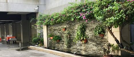 Un edificio con un muro de piedra y plantas en macetas.