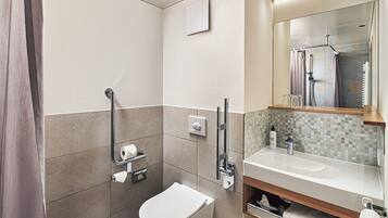 A modern bathroom with a toilet, bidet, and sink.