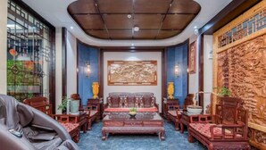 A traditional-style living room with a central coffee table, two sofas, and a massage chair. - Vyluk Hotel Jianshui Gucheng (Honghe)