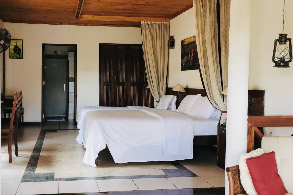 Una habitación de hotel con cama, una silla, un escritorio y un armario.