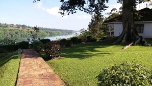 Un camino que lleva a una casa con vista a un lago y colinas.