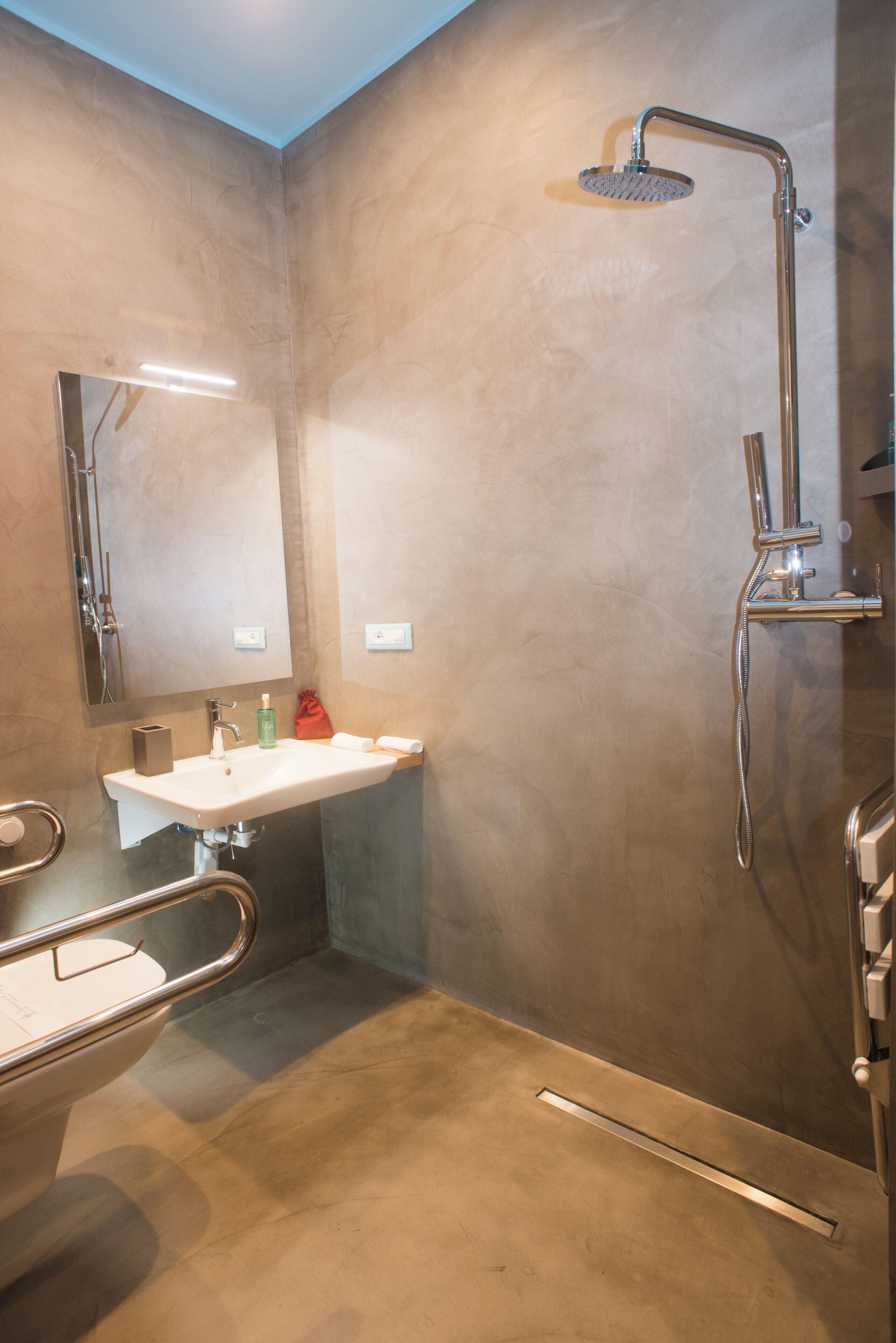 A modern bathroom with a shower, sink, and toilet.