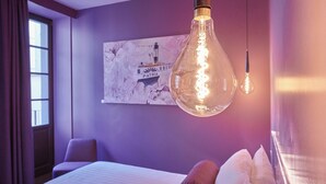 A hotel room with a bed, a hanging light fixture, and a wall-mounted artwork. - 73 Boutique Hotel   (Como)