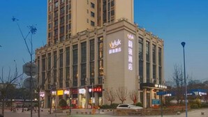 A tall, beige-colored hotel with multiple floors and a prominent sign on the front. - Vyluk Hotel Chengdu UESTC (Chengdu)