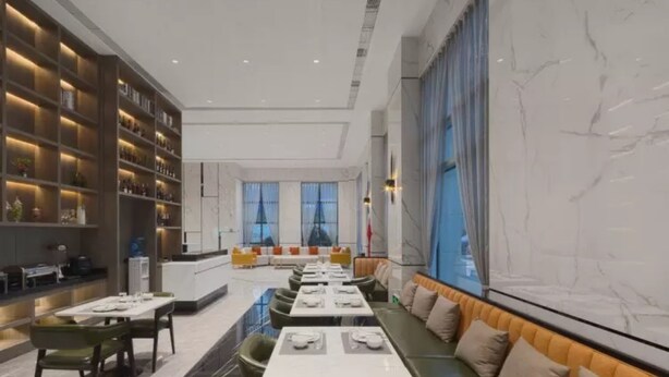 A modern dining area with a long table set for a meal, a seating area with cushioned benches, and a large window with a view. - Vyluk Hotel Chengdu UESTC (Chengdu)