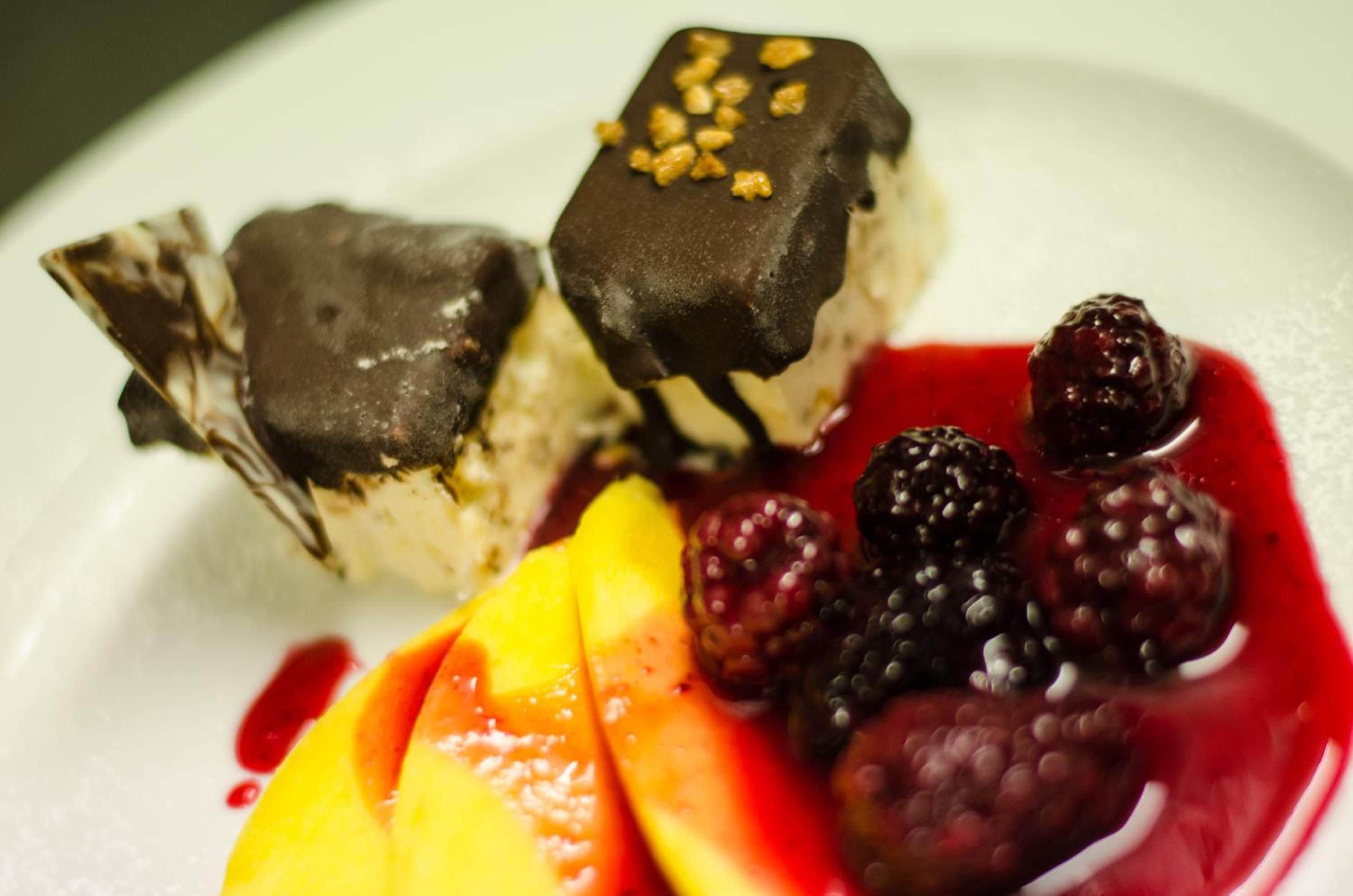 A dessert plate with chocolate-covered items and fresh berries.