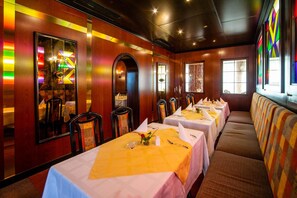 A restaurant with long tables, chairs, and a seating area with cushioned benches. - Hotel Gasthof Zur Heinzebank (Wolkenstein)