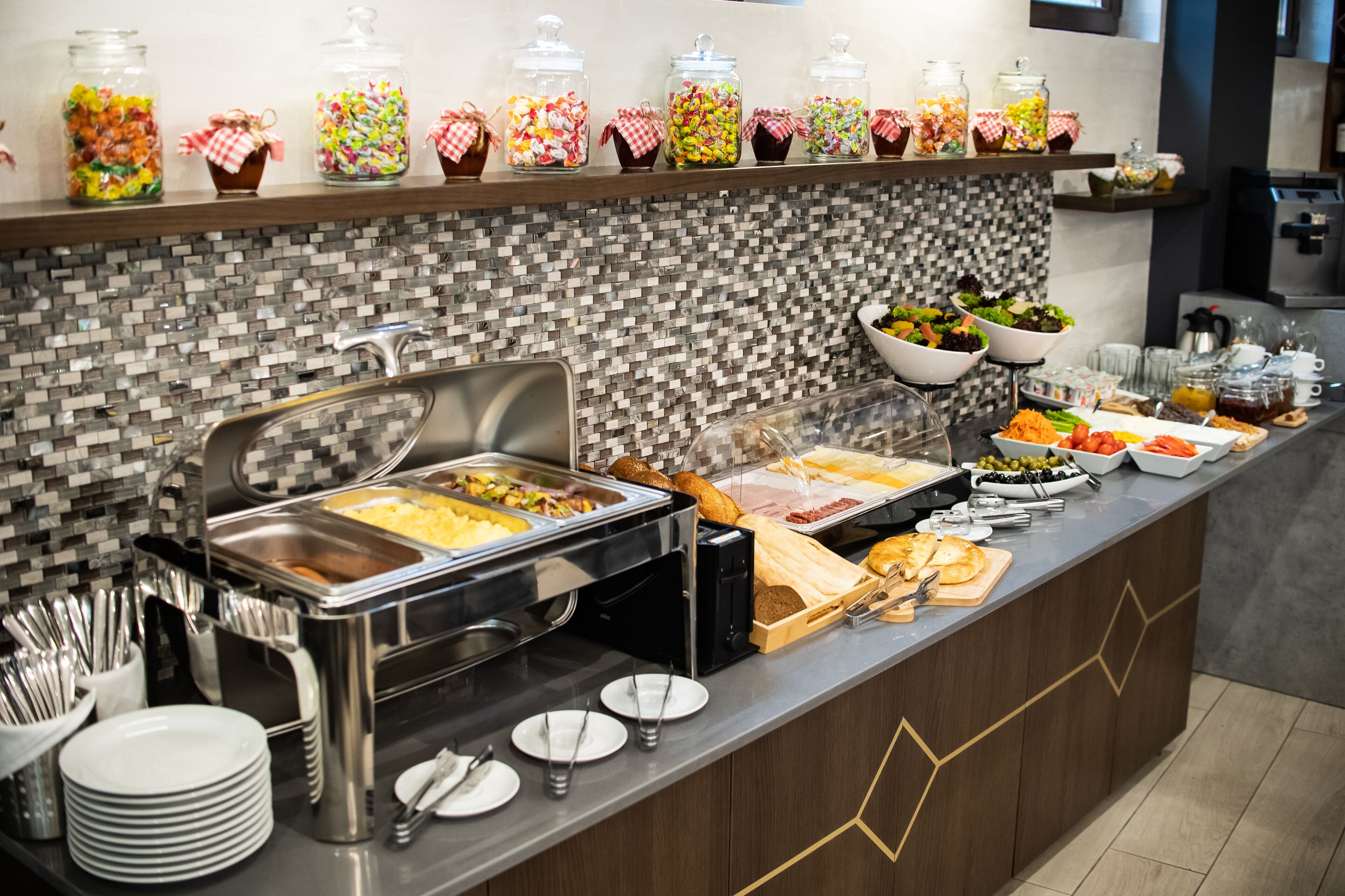 A buffet setup with various food items and utensils.