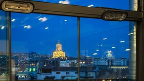A restaurant with a view of a cityscape, including a prominent church and a government building. - Silver 39 Corner Hotel (Tbilisi)