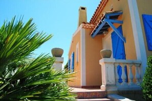 Stunning Mediterranean-style building with a curved facade and lush green surroundings.