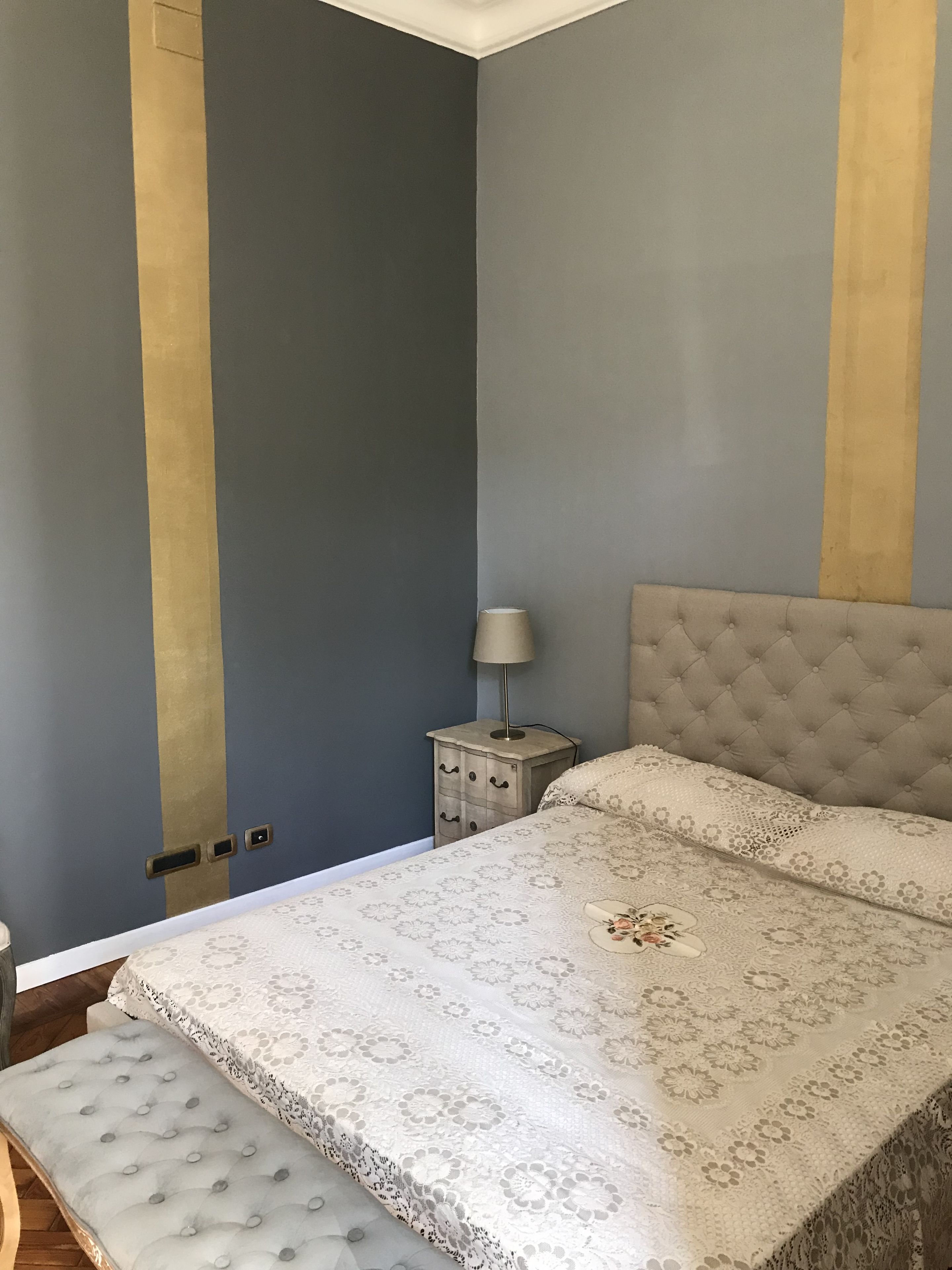 Una camera da letto con un letto, un comodino e una lampada.