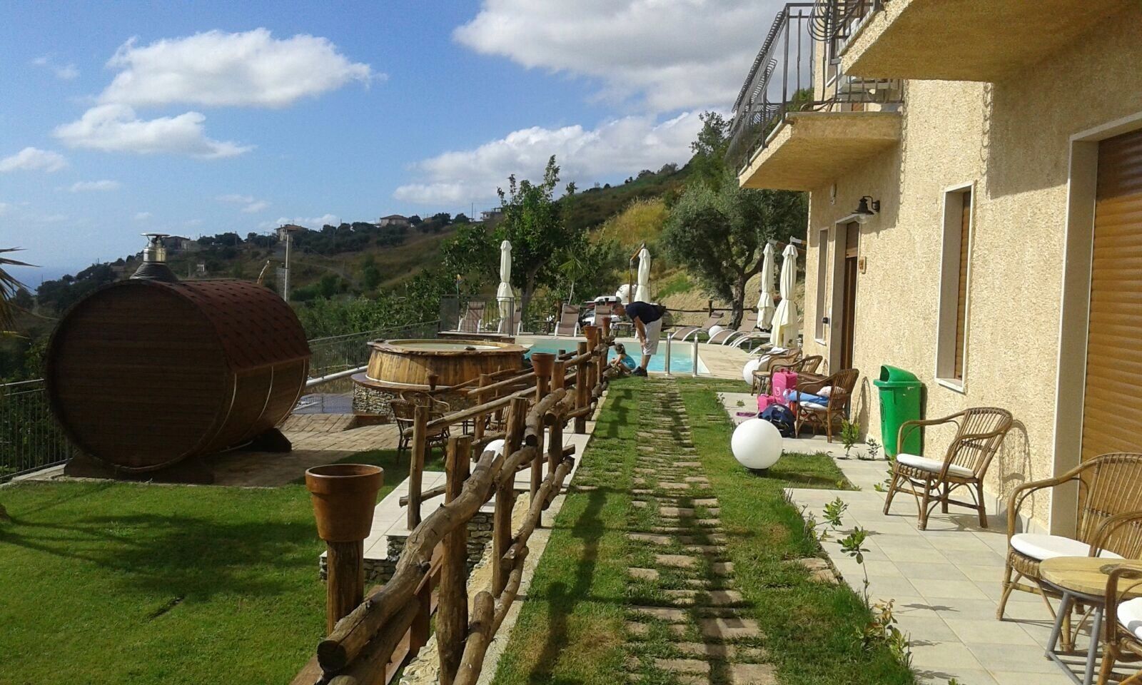 Una villa con piscina, mobiliario exterior y vistas a las colinas.