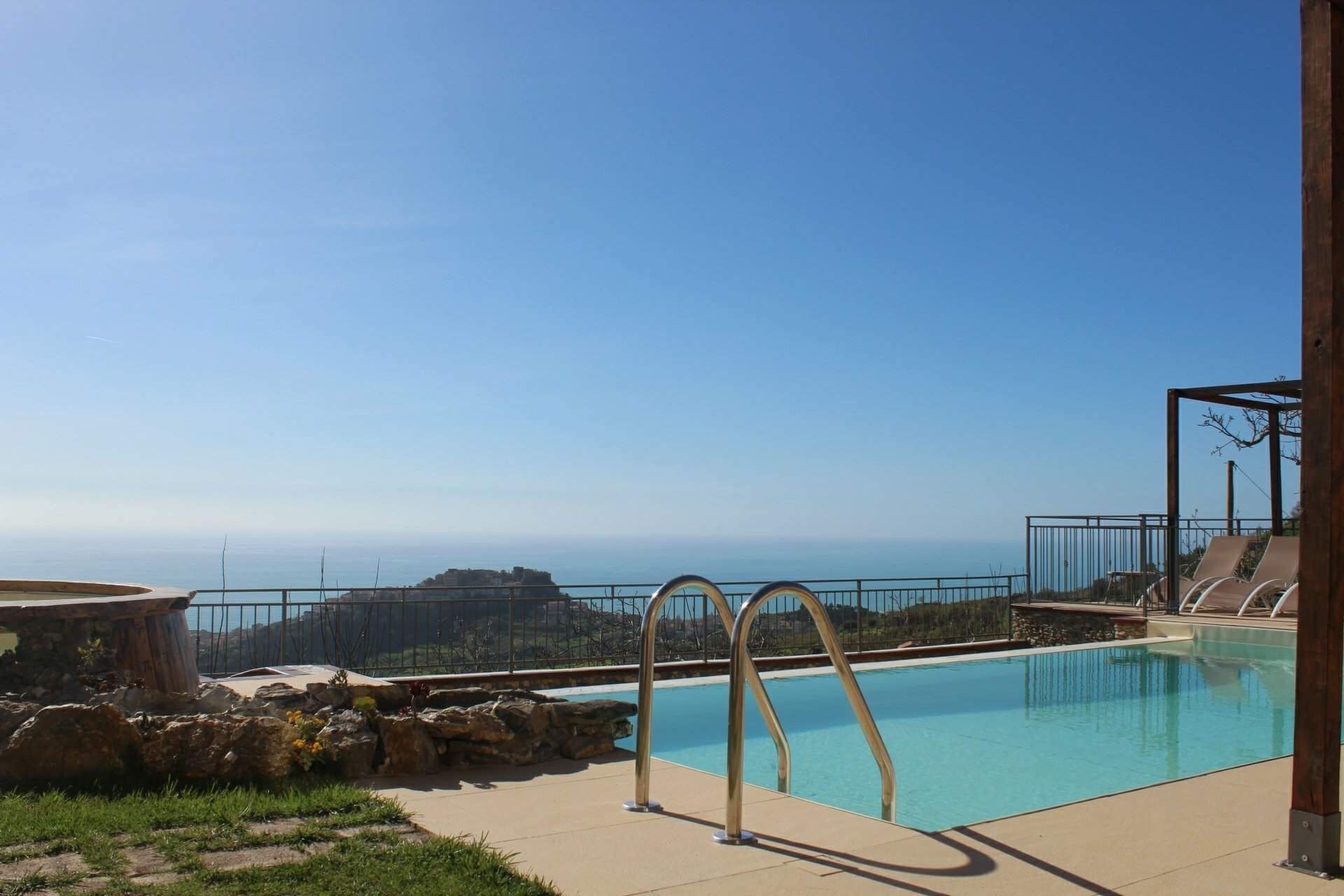 Piscina con vistas al océano y un paisaje rocoso.
