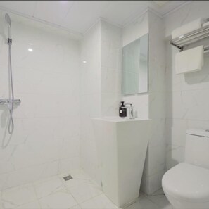 A bathroom with a shower, a toilet, and a sink with a mirror above it. - Vyluk Hotel Chongqing Airport (Chongqing)