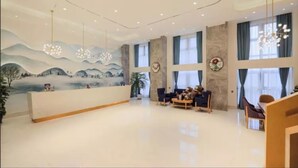 A spacious lobby with a reception desk, seating area, large windows, and a mural on the wall. - Vyluk Hotel Chongqing Airport (Chongqing)