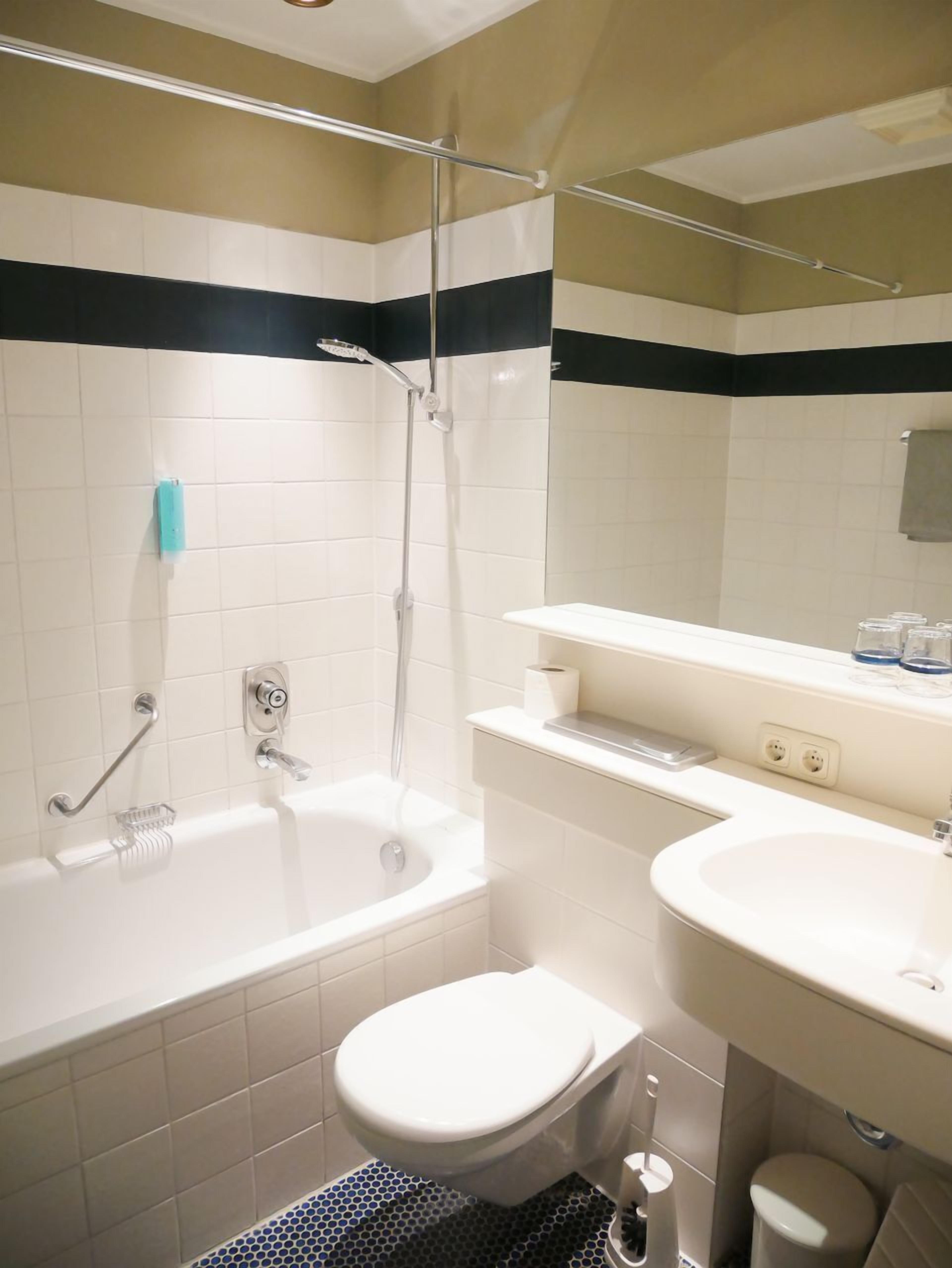 Un baño con bañera, inodoro y lavamanos.