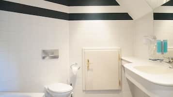Une salle de bain moderne équipée de toilettes, d’un lavabo et d’une baignoire.