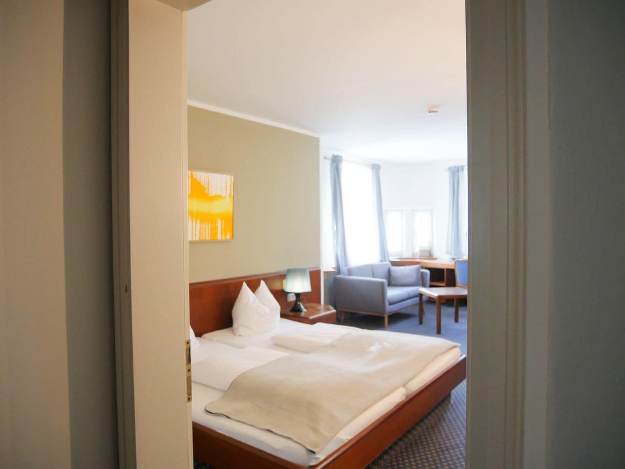 Et hotelværelse med en seng, et skrivebord og en stol.