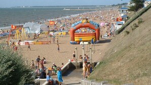 Een strand met opblaasbare constructies, een zandvlakte en een grashelling.