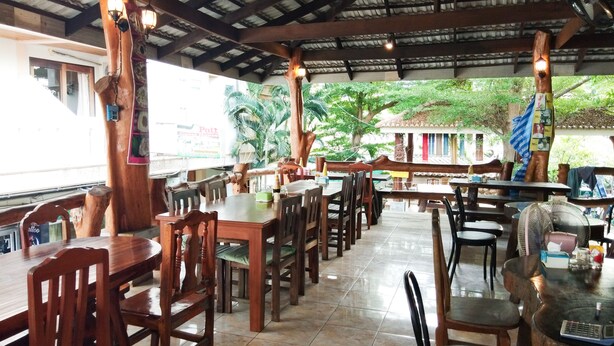 Un ristorante con arredi in legno e pavimento piastrellato.