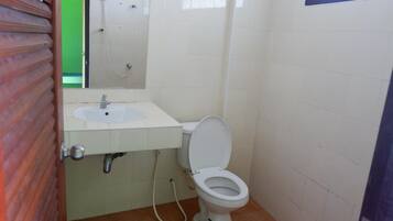A small bathroom with a white sink, toilet, and a mirror above the sink.