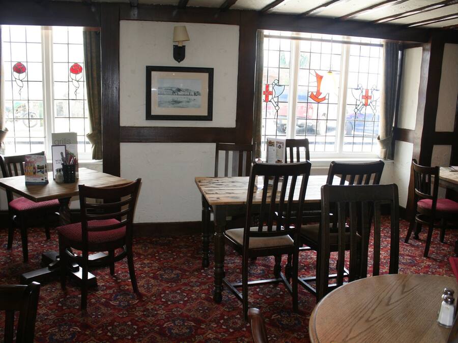 Une auberge traditionnelle, avec des meubles en bois, une moquette à motifs et une vue par les fenêtres.