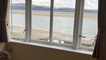 Enjoy a serene view of the water and distant hills from this room's large window.