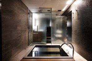 Un baño moderno con ducha envuelta en vidrio, bañera integrada y diseño elegante.