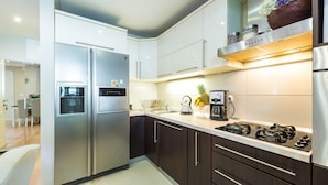 A modern kitchen with stainless steel appliances, dark wooden cabinets, and a gas stove. - Vacation house Cavtat (Konavle)
