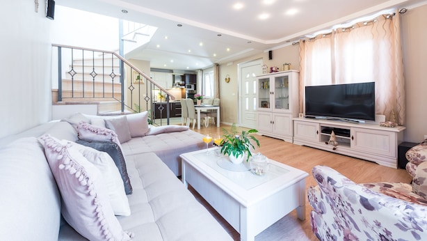 A modern living room with a sofa, a coffee table, and a TV. There is a staircase leading to an upper level. - Vacation house Cavtat (Konavle)