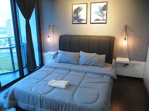 Una habitación de hotel moderna con una cama grande, vistas a la ciudad y dos luces fijadas a la pared.